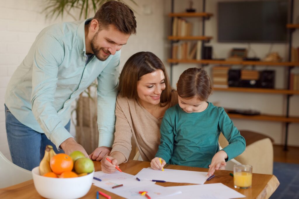 Family drawing together at a table.