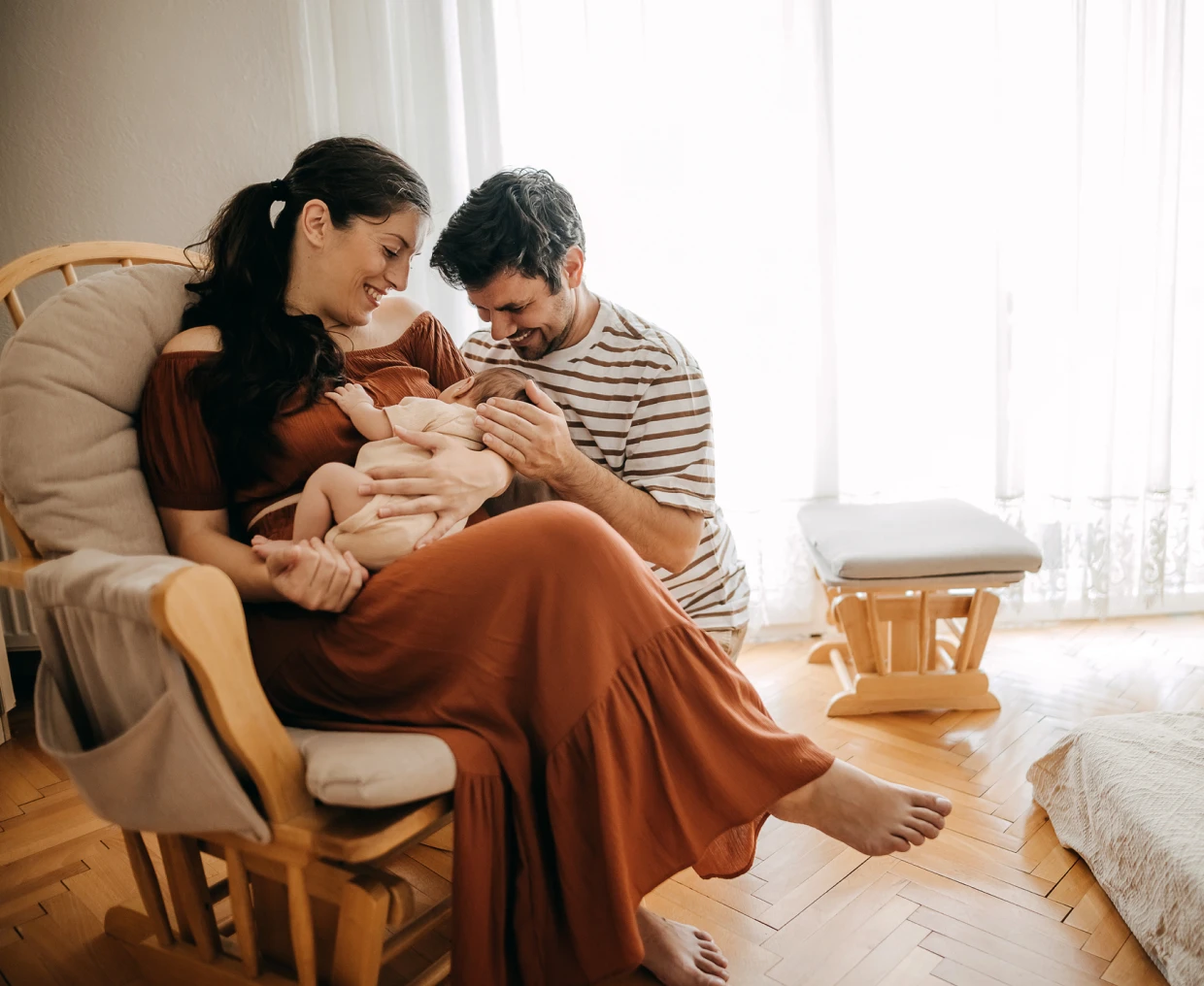 Family with newborn in cozy living room.