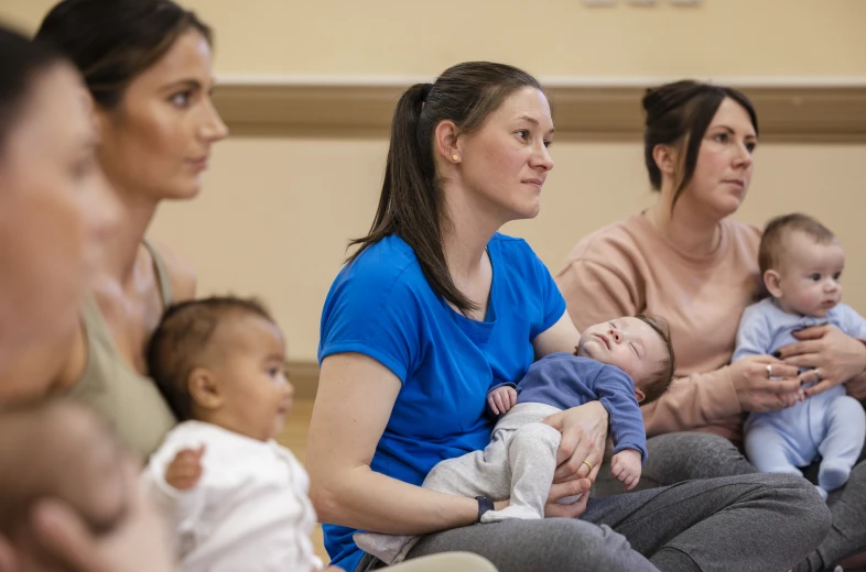 Mothers sitting with their babies in arms.